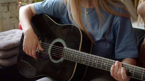 Midsection of man playing guitar