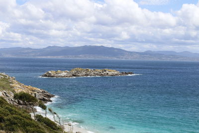 Scenic view of sea and mountains against sky