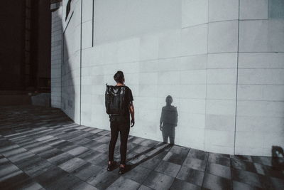 Rear view of man and woman walking on sidewalk