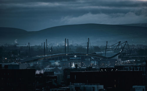 High angle view of cranes in city against sky