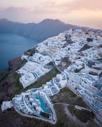 High angle view of townscape by sea against sky