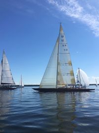 Full length of sailing boats in calm sea