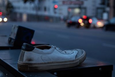 Close-up of illuminated shoes on street in city