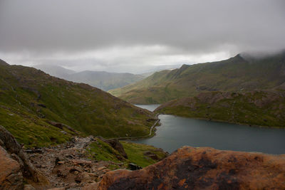 Scenic view of river and mountains against sky