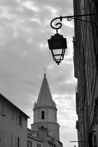Low angle view of street light amidst buildings against sky