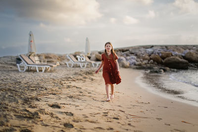  girl and stones at sunset on the ocean. walking along the seashore in silence at sunset.