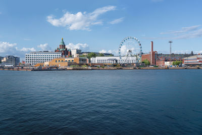 Buildings by sea against sky