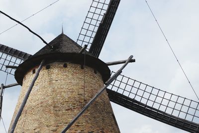 Low angle view of traditional windmill against sky