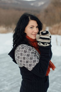 Smiling woman standing on snow covered field