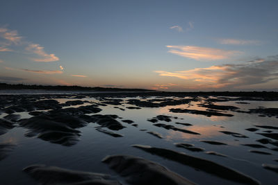 Scenic view of beach against sky during sunset