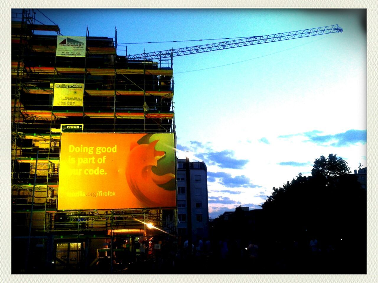 building exterior, transfer print, communication, text, architecture, built structure, city, western script, auto post production filter, sky, low angle view, power line, information sign, advertisement, road sign, road signal, guidance, yellow, city life, sunset