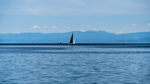 Sailboat sailing on sea against sky