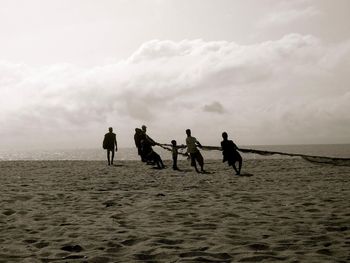 People at beach against sky