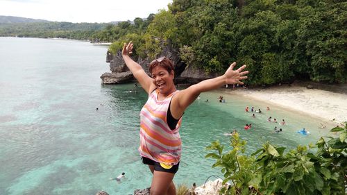 Portrait of woman posing over beach against sky 