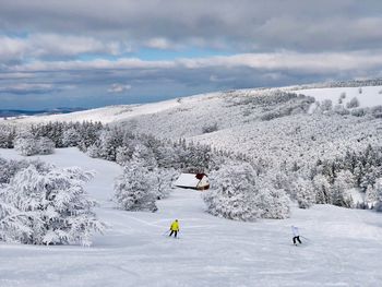 People on snowcapped mountain against sky