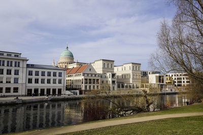 Buildings in city against cloudy sky