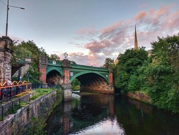 Arch bridge over river against sky