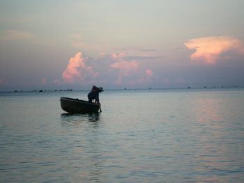 Boats in sea at sunset