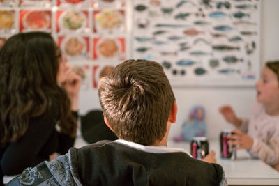 Rear view of two people looking at camera