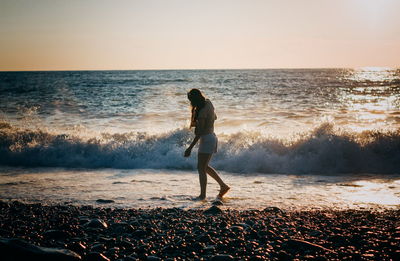 Brunette woman at the sea on sunset