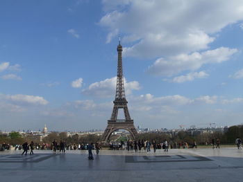 Tourists in front of liberty tower against sky