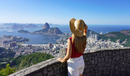 Woman on terrace in rio de janeiro with guanabara bay and the cityscape of rio de janeiro, brazil