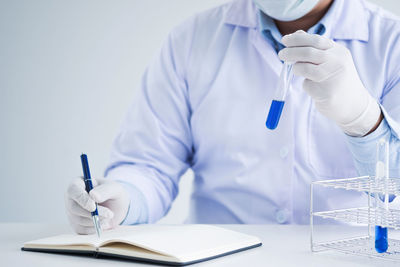 Midsection of man reading book on table