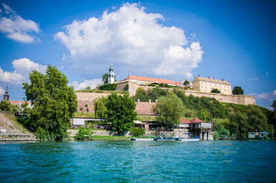 View of swimming pool by buildings against sky