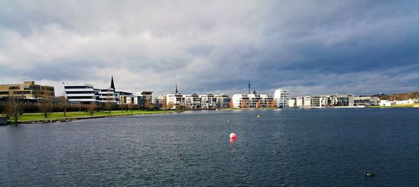 View of cityscape against cloudy sky