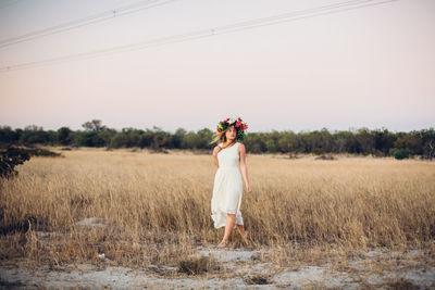 Woman standing on field against clear sky