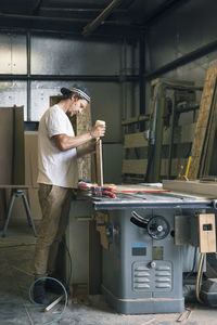 Side view of carpenter working at workshop