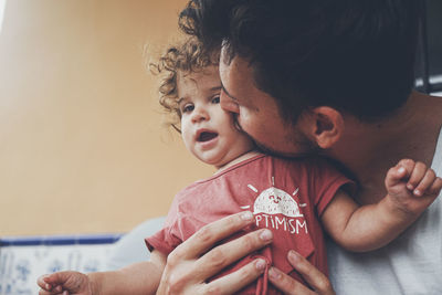 Close-up of mother carrying daughter at home