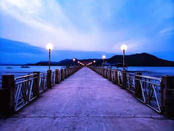 Empty pier on sea against sky at dusk