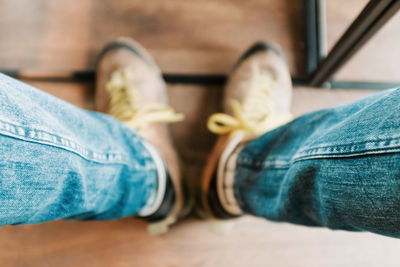 Low section of man wearing shoes on hardwood floor