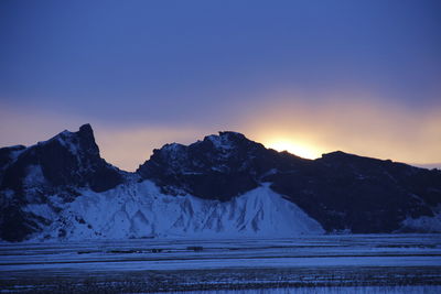 Scenic view of snow mountains against clear sky during sunset