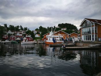 Houses by river against sky