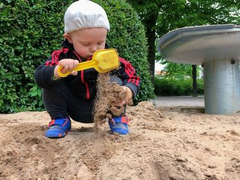 Boy playing with sand at park