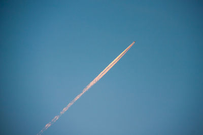 Lonely flying plane against the blue sky