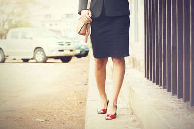 Low section of woman standing on street