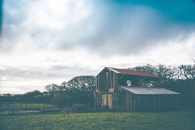 Built structure on countryside landscape against clouds