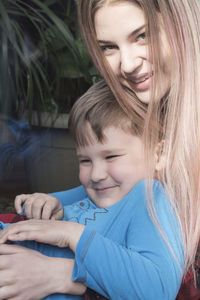 Sister embracing cute brother at back yard