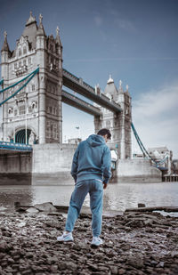 Full length of man standing on bridge in city