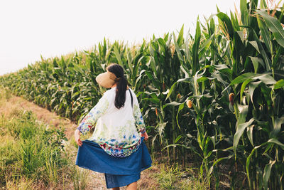 Rear view of woman standing on field