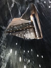 Low angle view of illuminated lights on wet table