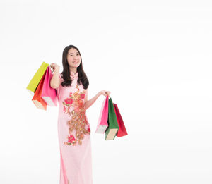 Happy woman standing against white background