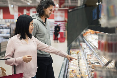 Young couple shopping during inflation in supermarket