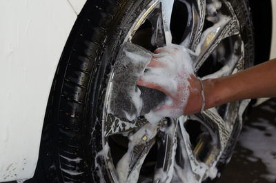 Cropped hand cleaning car spoke 