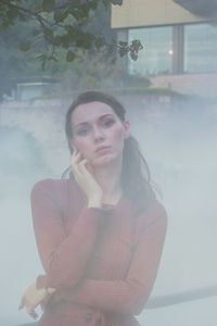 Portrait of beautiful young woman standing against wall