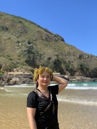 Portrait of smiling young man standing on beach