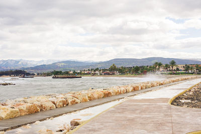 Scenic view of river by city against sky